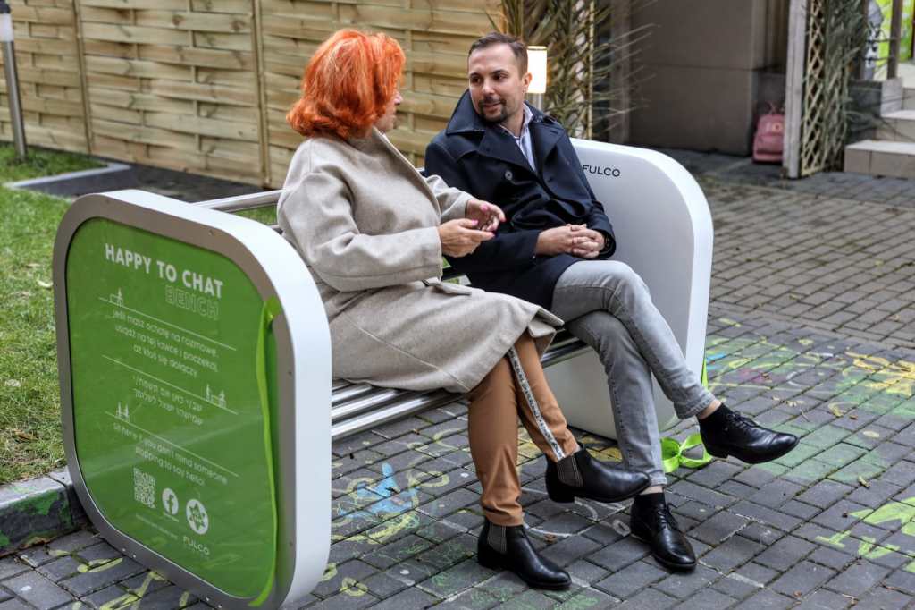 Image of woman and man talking on a chat bench